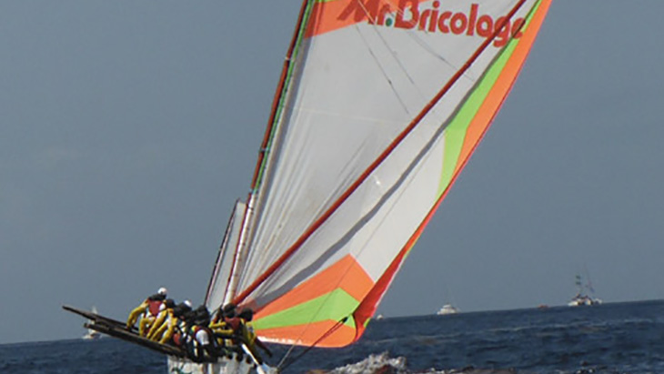Sailing at sea during the Tour des Yoles Rondes with the logo of its partner Mr Bricolage
